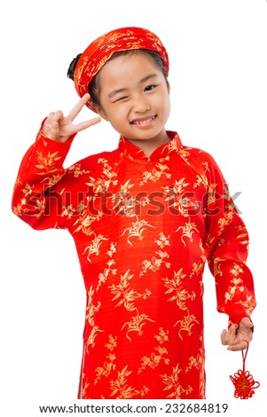 Cute little girl in ao dai dress winking and showing two fingers