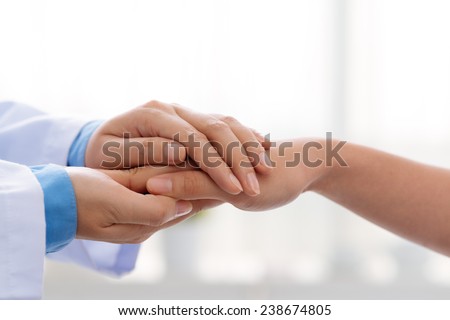 Hand of doctor reassuring her female patient