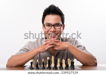 Portrait of happy Asian chess player looking at the camera