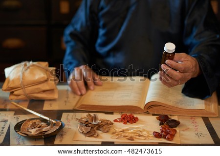 Practitioner of Asian traditional medicine giving medicine he prepared