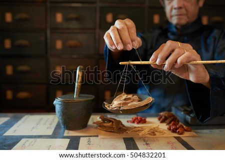 Man measuring ingredients in traditional Asian apothecary
