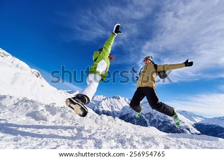 stock photo woman and a man in a jump in the mountains of austria against the blue sky and snow capped mountains 256954765