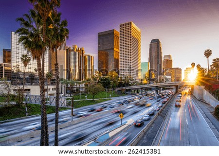 Los Angeles downtown buildings and highway car traffic at sunset