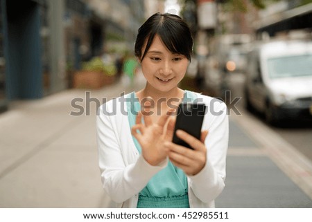 https://thumb7.shutterstock.com/display_pic_with_logo/1051921/452985511/stock-photo-young-asian-woman-walking-street-texting-cell-phone-452985511.jpg