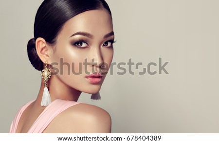 Asian model fashion girl with tassel earrings and pink dress.