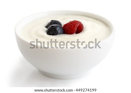 Ceramic bowl of white yogurt with berries isolated on white background.