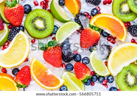 Fresh fruits background.Slices of fresh fruits top view on ice.