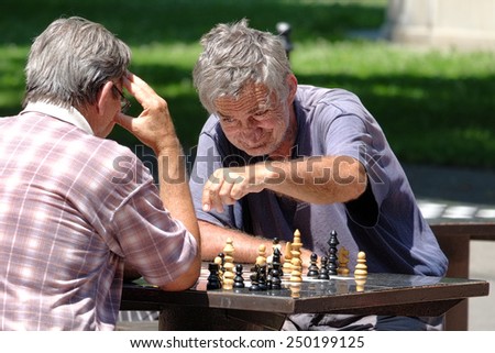 BELGRADE, SERBIA - JULY 29, 2014: two middle-aged men are playing a match of chess in Kalemegdan Fortress of Belgrade Old Town. Shot in 2014