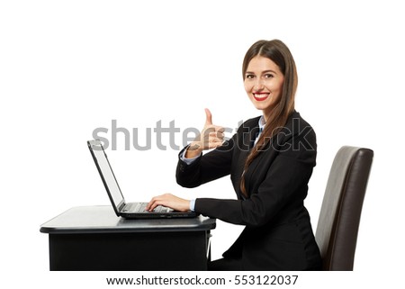 Happy businesswoman showing thumbs up sign sitting at her laptop