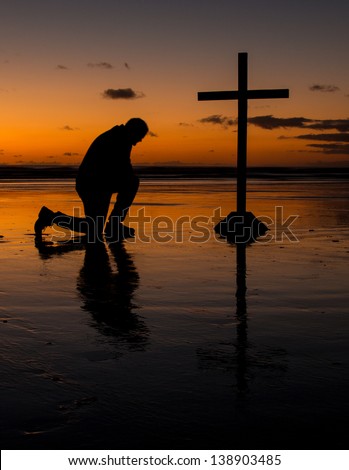 https://thumb7.shutterstock.com/display_pic_with_logo/1130204/138903485/stock-photo-cross-with-a-man-kneel-in-prayer-on-a-beach-at-sunset-138903485.jpg
