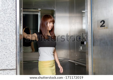 Asians pushing elevator buttons
