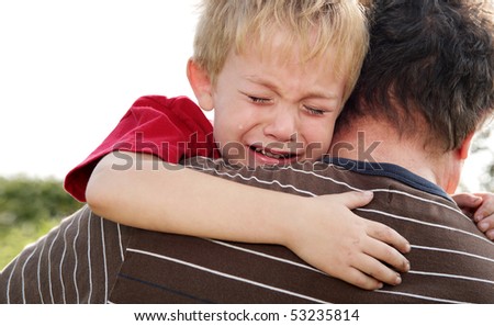 Young boy being comforted by his father