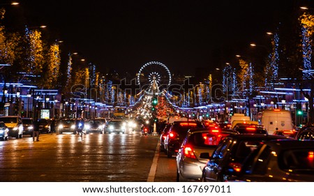 Avenue des Champs-Elysees in Paris decorated with Christmas illumination and the ferris wheel at horizon.