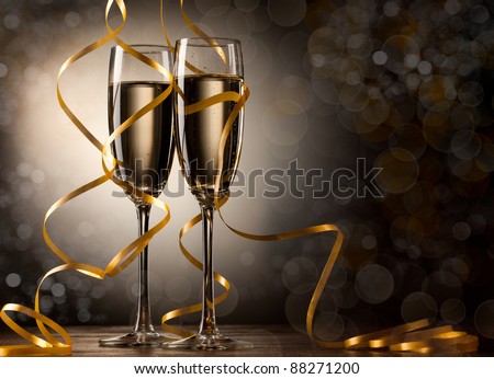 Pair glass of champagne. New year celebration or wedding concept theme. Paper streamer with defocused lens blur over background. Celebration concept.
