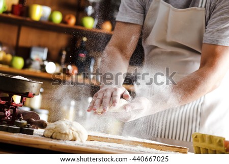 Male baker prepares bread. Male baker slaps on dough. Making bread.