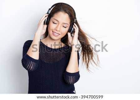 beautiful young asian woman listening to music with headphones