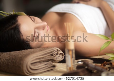Beautiful woman having relaxing in spa massage salon.