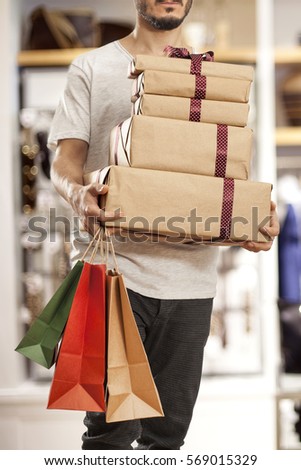 Man holding paper shopping bag with gift boxes