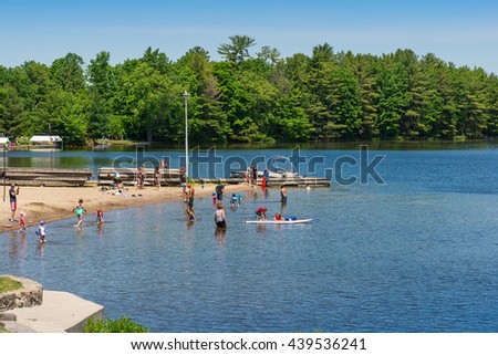 Gravenhurst Ontario June Adults And Children Enjoying A Sandy Beach Gravenhurst Ontario June Adults And Children Enjoying A Sandy Beach