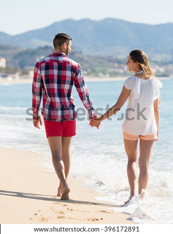 https://thumb7.shutterstock.com/display_pic_with_logo/124564/396172891/stock-photo-smiling-young-couple-walking-on-sandy-beach-holding-hands-396172891.jpg