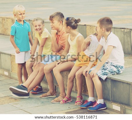 Glad positive boys and girls in school age having fun playing charades