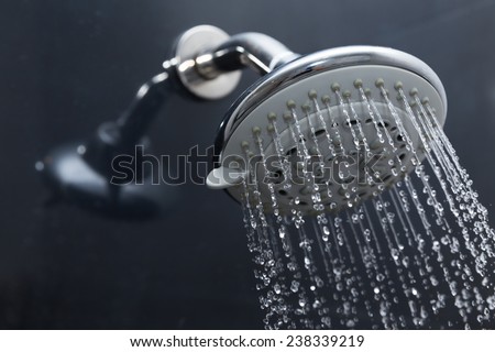 shower head in bathroom with water drops flowing