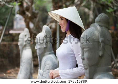HUE, VIETNAM, MAY 3: Vietnamese girl with Ao Dai in Tu Duc royal tomb on May 3, 2014 in Hue, Vietnam. Ao dai is famous traditional costume for woman in VIetnam.