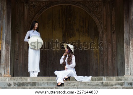 HUE, VIETNAM, MAY 3: Vietnamese girls with Ao Dai in Tu Duc royal tomb on May 3, 2014 in Hue, Vietnam. Ao dai is famous traditional costume for woman in VIetnam.