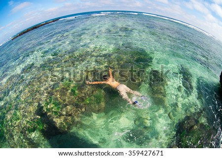 Young man swim in transparent beach in Ly Son island, Quang Ngai, Vietnam. Traveler explore the beach.