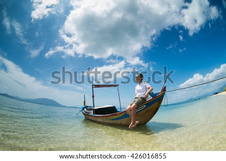 A young tourist on boat in Diep Son beach, Nha Trang, Vietnam.
