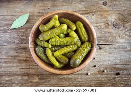 Pickles. Bowl of pickled gherkins (cucumbers) over rustic wooden background with copy space.