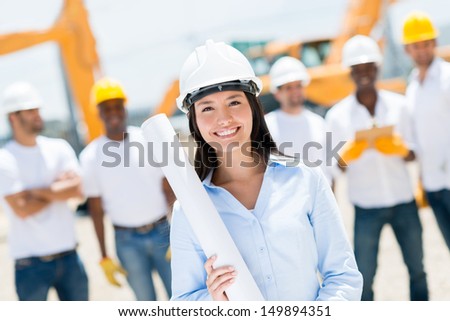Female engineer at a construction site looking happy