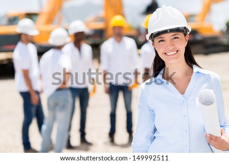 Female architect at a construction site looking happy