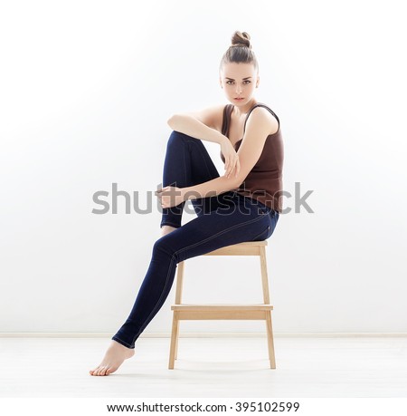 https://thumb7.shutterstock.com/display_pic_with_logo/1306012/395102599/stock-photo-elegant-woman-sitting-on-a-chair-in-blue-jeans-in-the-studio-395102599.jpg