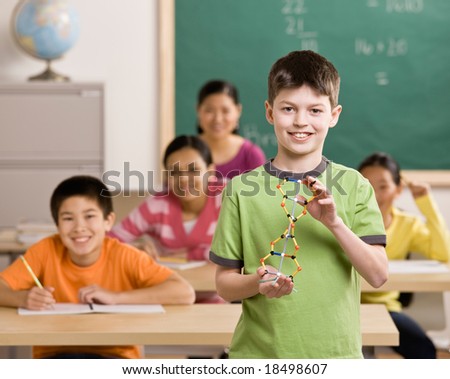 Student holding molecular model in science classroom