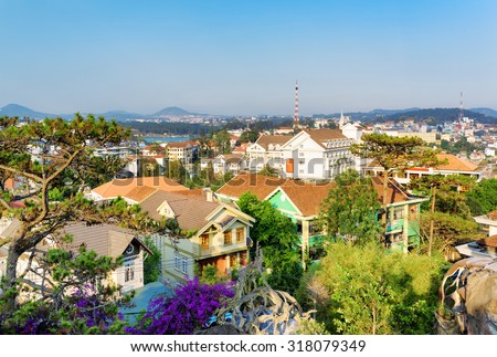 Beautiful houses with tile roofs in the Da Lat city (Dalat) on the blue sky background in Vietnam. Da Lat and the surrounding area is a popular tourist destination of Asia.
