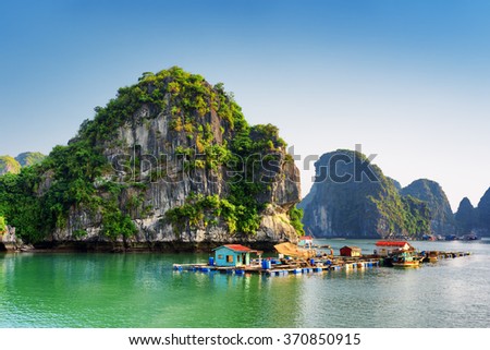 Beautiful view of floating fishing village in the Halong Bay (Descending Dragon Bay) at the Gulf of Tonkin of the South China Sea, Vietnam. Landscape formed by karst towers-isles in various sizes.