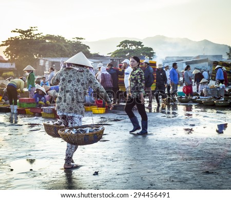 LONG HAI, VIET NAM - MAY 31 2015: A woman carring basket full of fishes to the early morning market