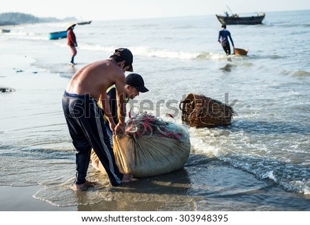 Long Hai, Ba Ria - Vung Tau, Vietnam - 31 May 2015: Fishermen carrying net back home from a long trip at Long Hai, Ba Ria - Vung Tau, Vietnam