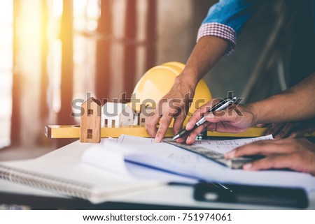 architect man working with blueprints,engineer inspection in workplace for architectural plan,sketching a construction project ,selective focus.