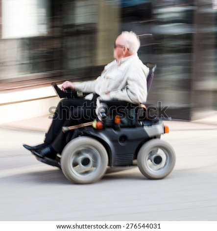 Old man in wheelchair. Intentional motion blur