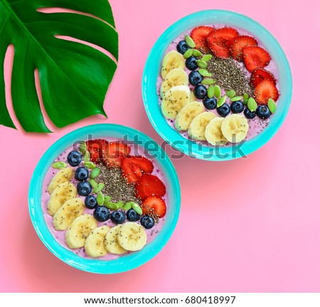 Berry smoothie bowls with chia seeds and pumpkin seeds, view from above