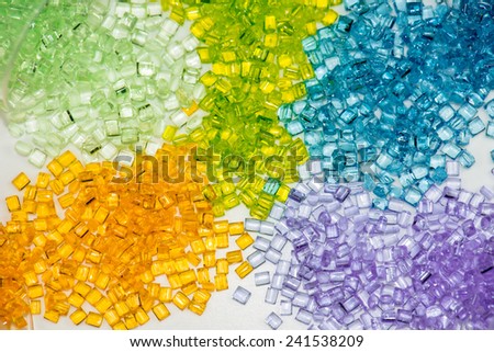 several different dyed polymer granulates in laboratory on table