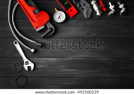 Plumber tools on a gray wooden background