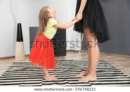 Mother dancing with daughter in the room