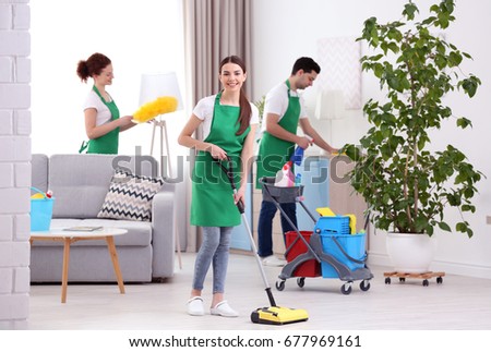 Cleaning service team working in living room