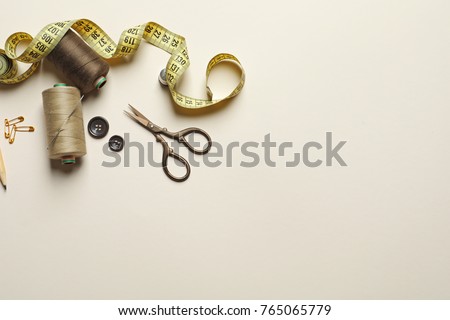 Set of tailoring tools and accessories on table, top view