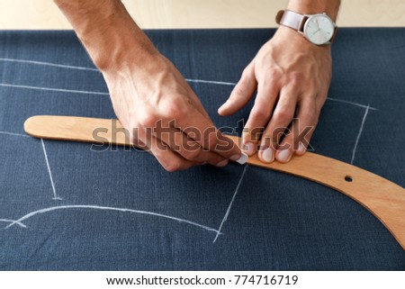 Young tailor working with textile, closeup