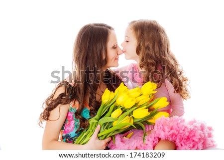 happy mother and daughter in the studio with a bouquet of yellow tulips. spring isolation. March 8, International Women's day, valentine's day, mother's day