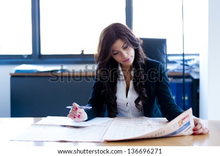 young business woman reading sitting at the desk on office background